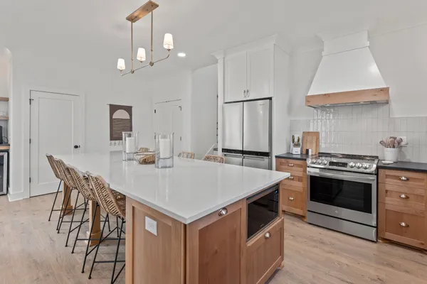 a kitchen that has a sink a stove and a table with chairs