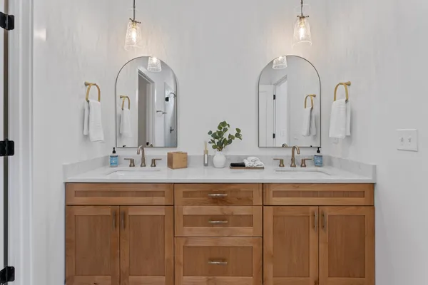 a bathroom with double vanity sinks and a mirror