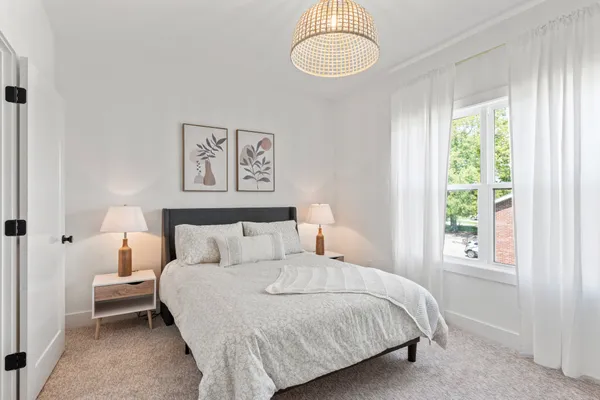 a bedroom with a bed and a large window