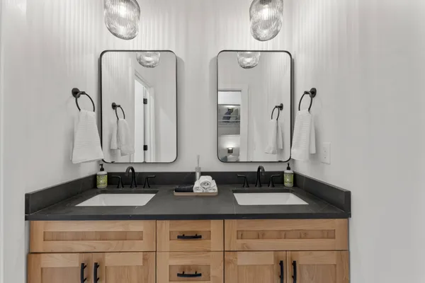 a bathroom with double vanity sinks and a mirror