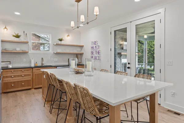 a kitchen with stainless steel appliances granite countertop a kitchen island a stove a table and chairs in it