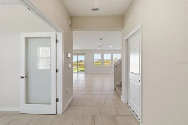 a view of an empty room with window and closet area