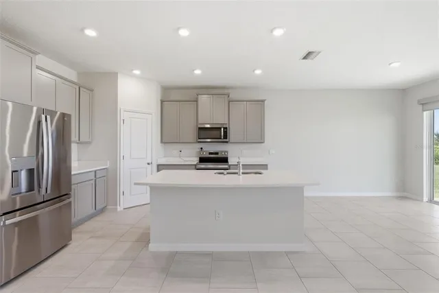 a kitchen with stainless steel appliances a sink and a large window