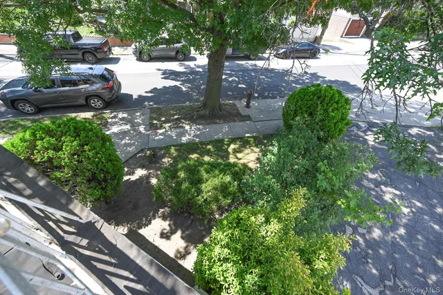 a view of hallway with window and wooden floor