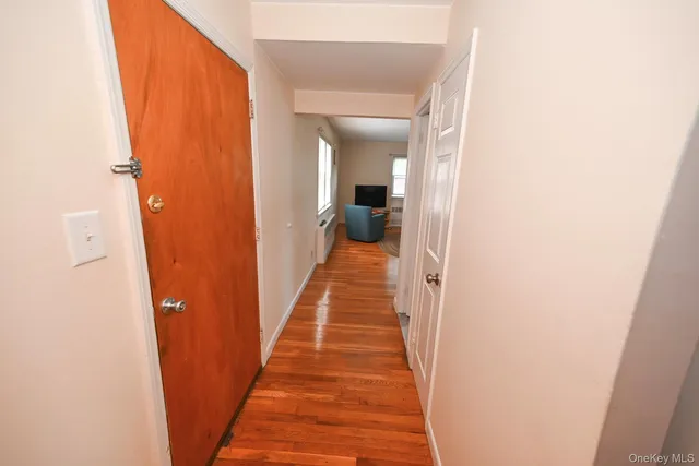 a view of a hallway with wooden floor