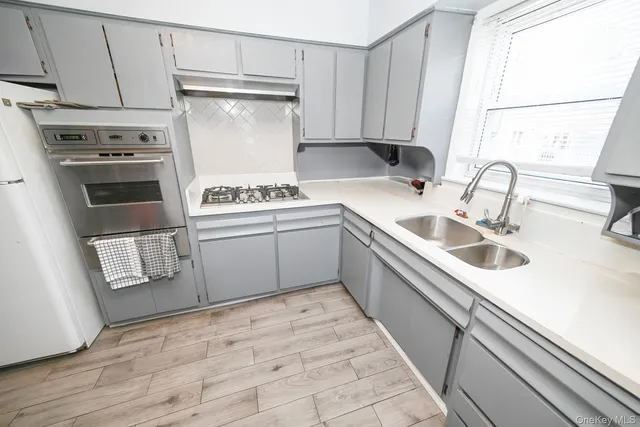 a kitchen with white cabinets sink and white appliances