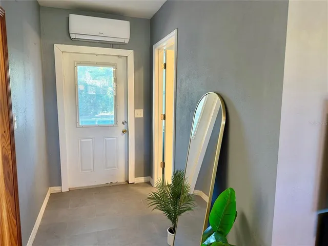 a view of a room that has a large window and potted plant