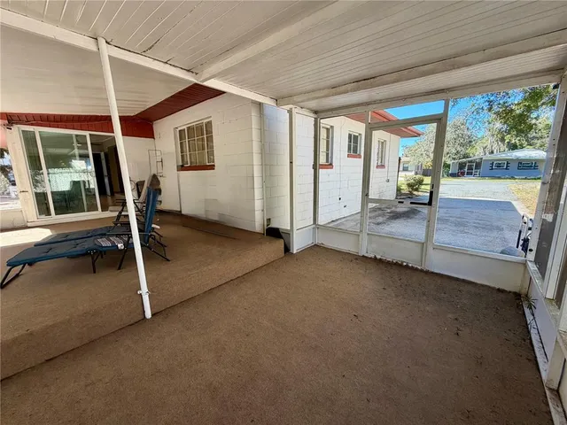 a view of an empty room with wooden floor and iron stairs