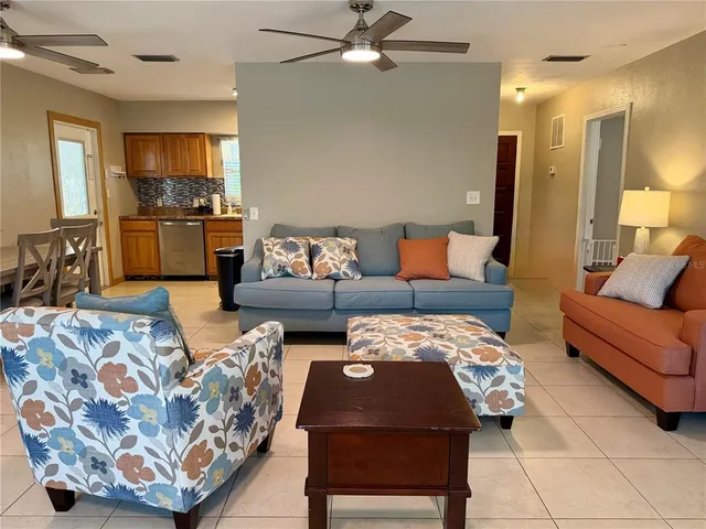 a living room with furniture and kitchen view