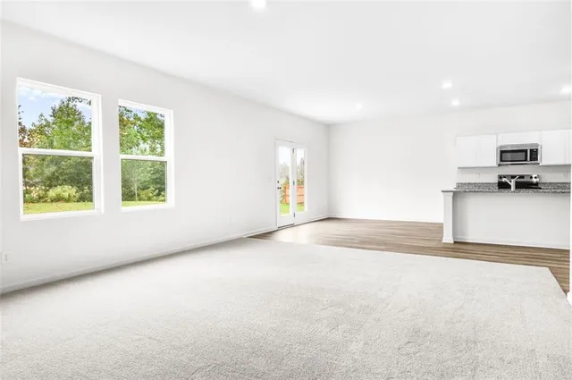 a view of a kitchen with a sink a microwave and a large window