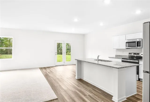 a kitchen with stainless steel appliances granite countertop a stove a sink and a microwave