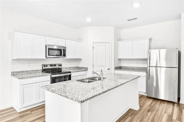 a kitchen with appliances a sink and a refrigerator