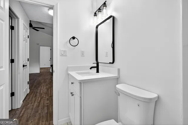 a bathroom with a sink a toilet a mirror and shower