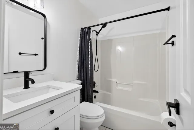 a bathroom with a bathtub shower sink vanity and toilet