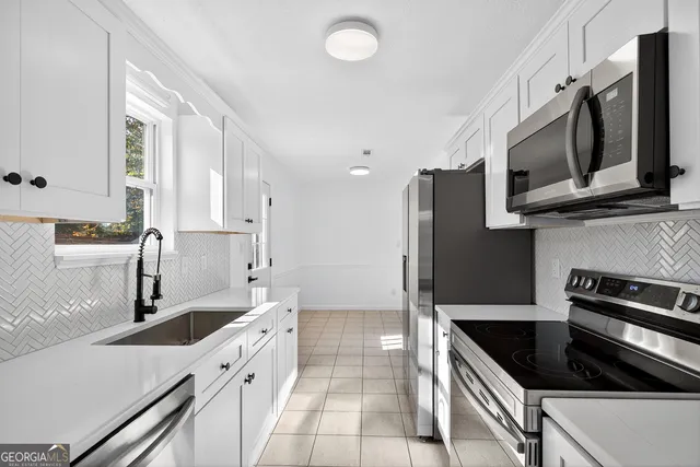 a kitchen with granite countertop a sink stove and refrigerator