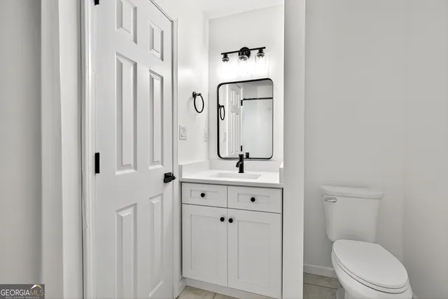 a bathroom with a toilet a sink and mirror
