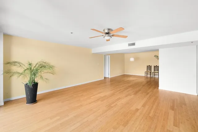 a view of a room with wooden floor and ceiling fan