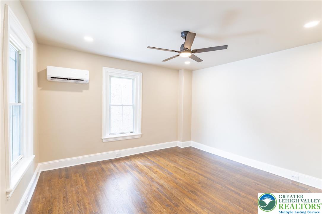 706 Main Street, Unit 2 Bethlehem, PA 18018 - Photo 2 of 20 an empty room with wooden floor fan and windows