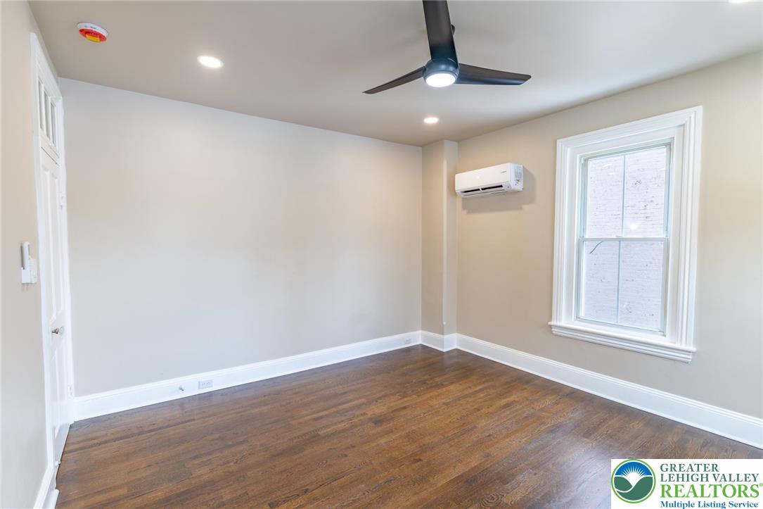 706 Main Street, Unit 2 Bethlehem, PA 18018 - Photo 4 of 20 an empty room with wooden floor cabinet and windows