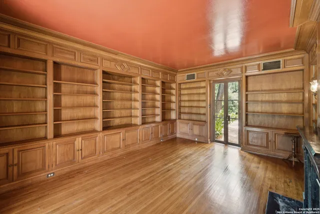 a view of an empty room with a fireplace and wooden floor