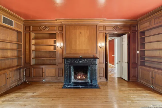 a view of an empty room with a fireplace and a window