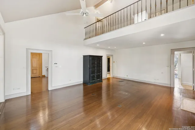 a view of a backyard with large trees and wooden fence