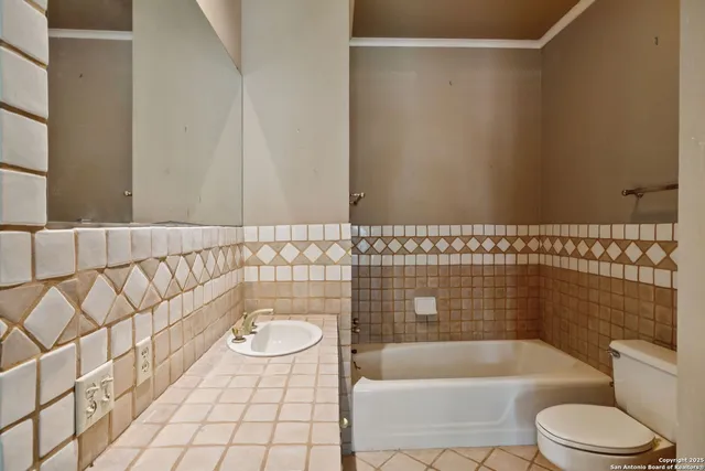 a view of a brick building next to a yard with large trees