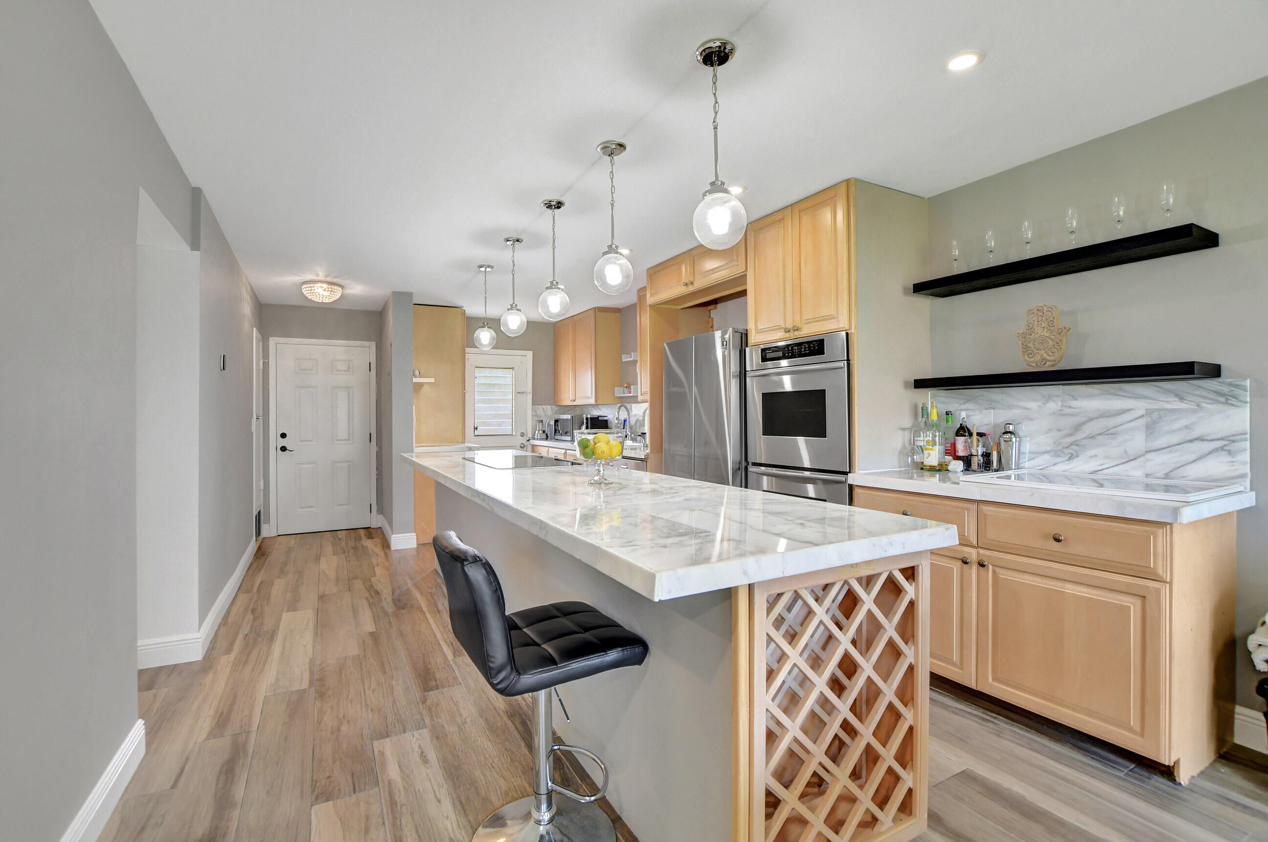 a large kitchen with stainless steel appliances kitchen island granite countertop a sink a stove and a wooden floors