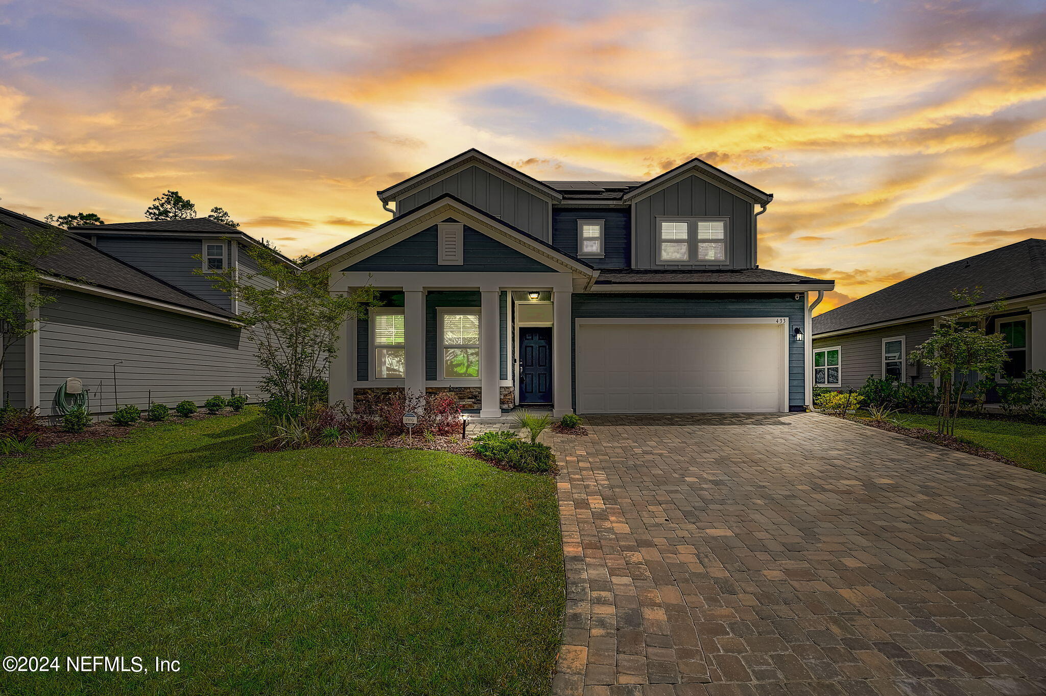 a front view of a house with a garden and yard