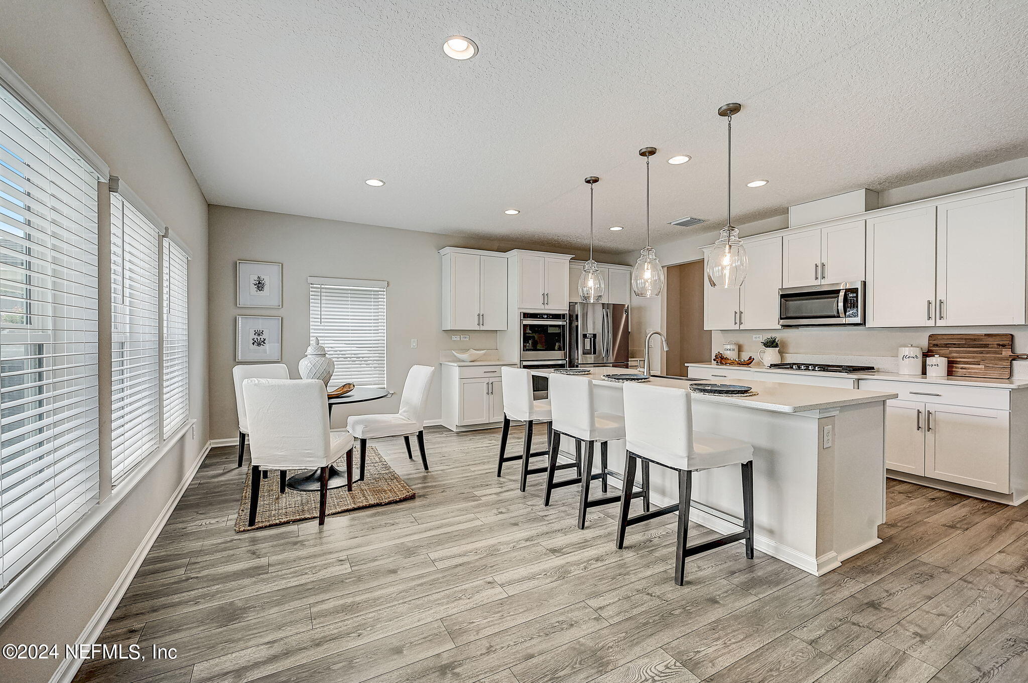 433 Watervale Drive St. Augustine, FL 32092 - Photo 19 of 66 a kitchen with white cabinets stainless steel appliances table chairs and a window