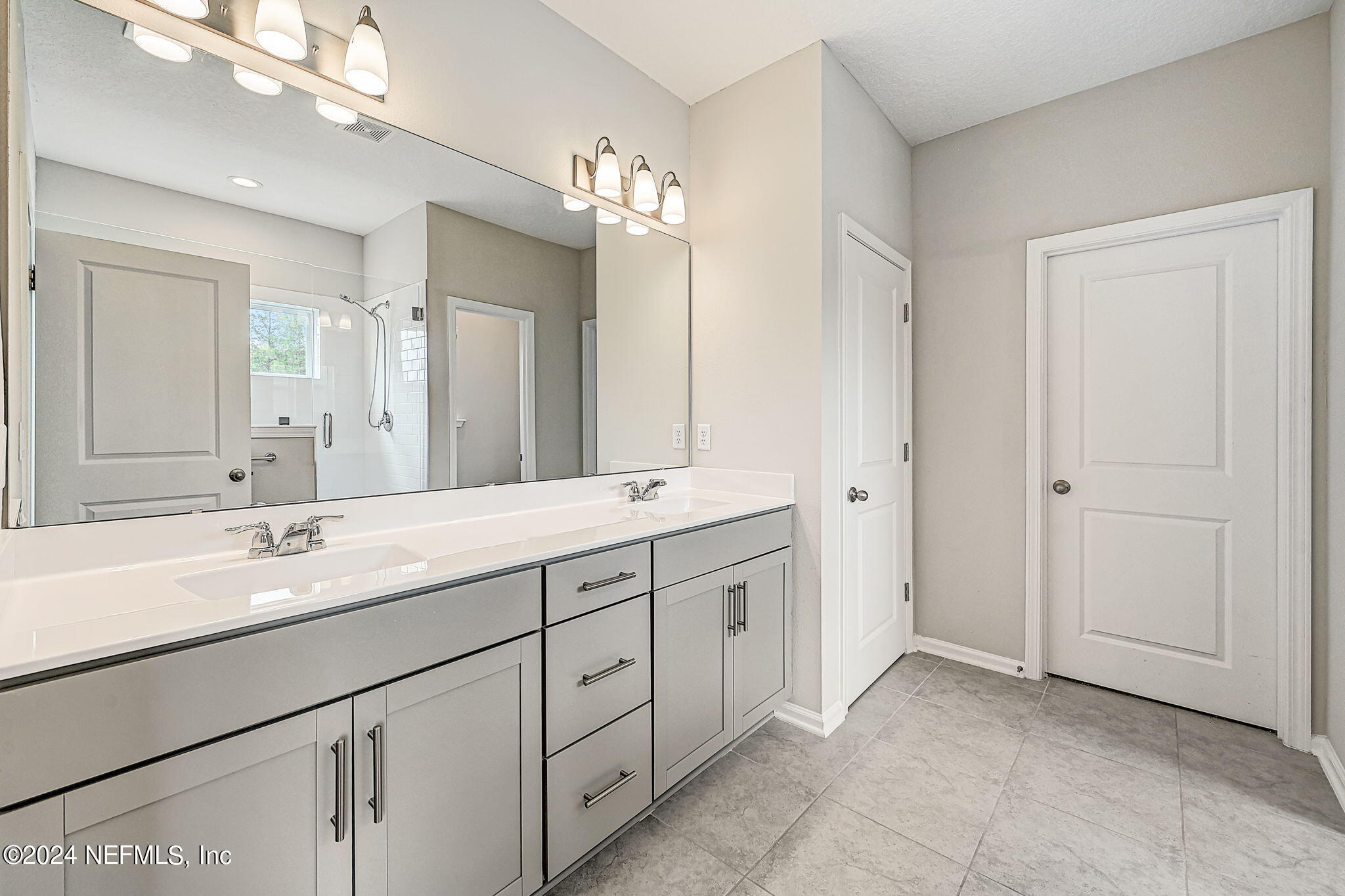 433 Watervale Drive St. Augustine, FL 32092 - Photo 28 of 66 a bathroom with a double vanity sink a mirror and a shower