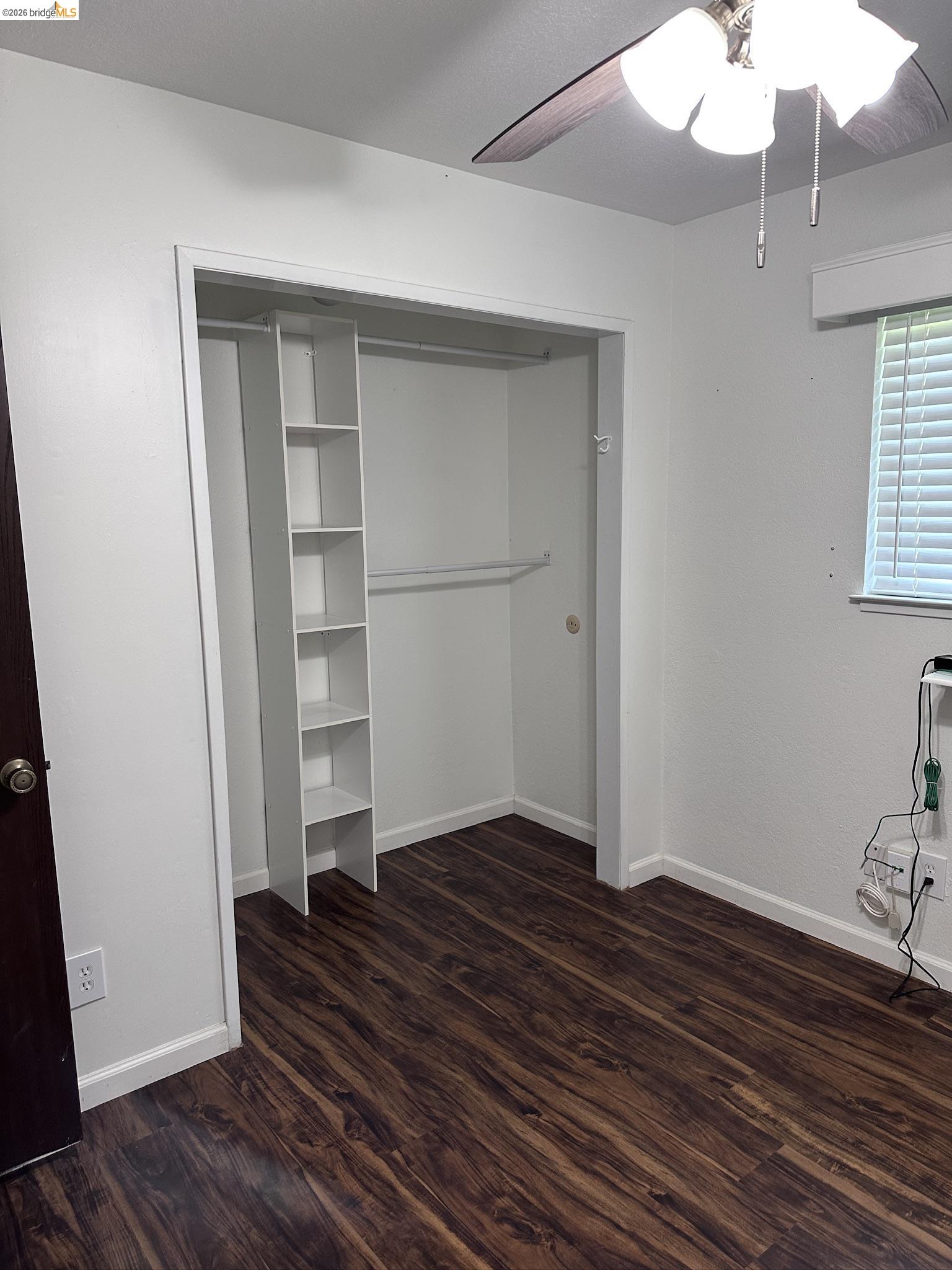 10458 Southworth Road Valley Springs, CA 95252 - Photo 17 of 24 Unfurnished bedroom with dark wood-type flooring, a closet, and a ceiling fan
