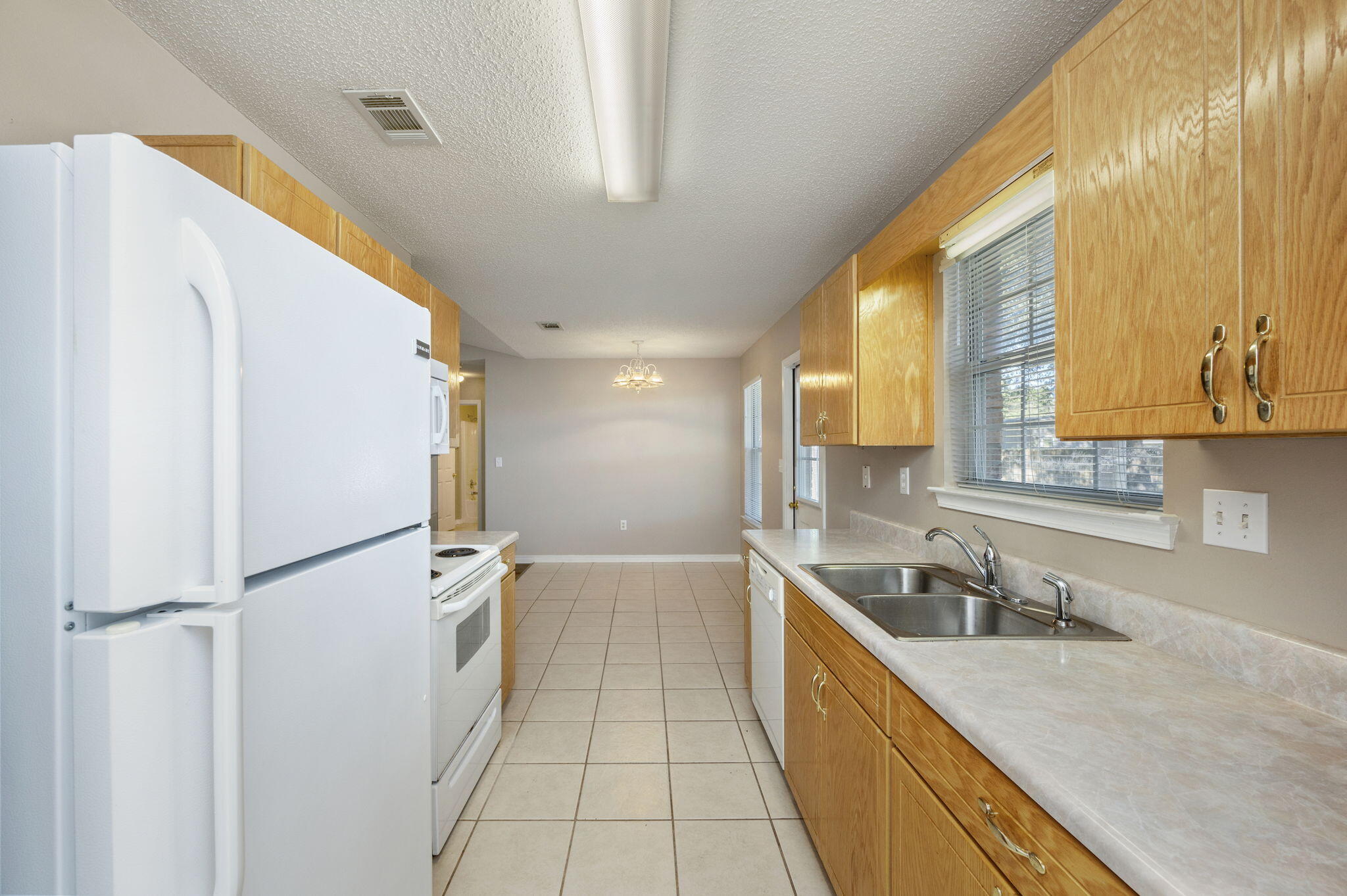 6235 Winstead Road Crestview, FL 32539 - Photo 11 of 31 a kitchen with a refrigerator a sink and a stove