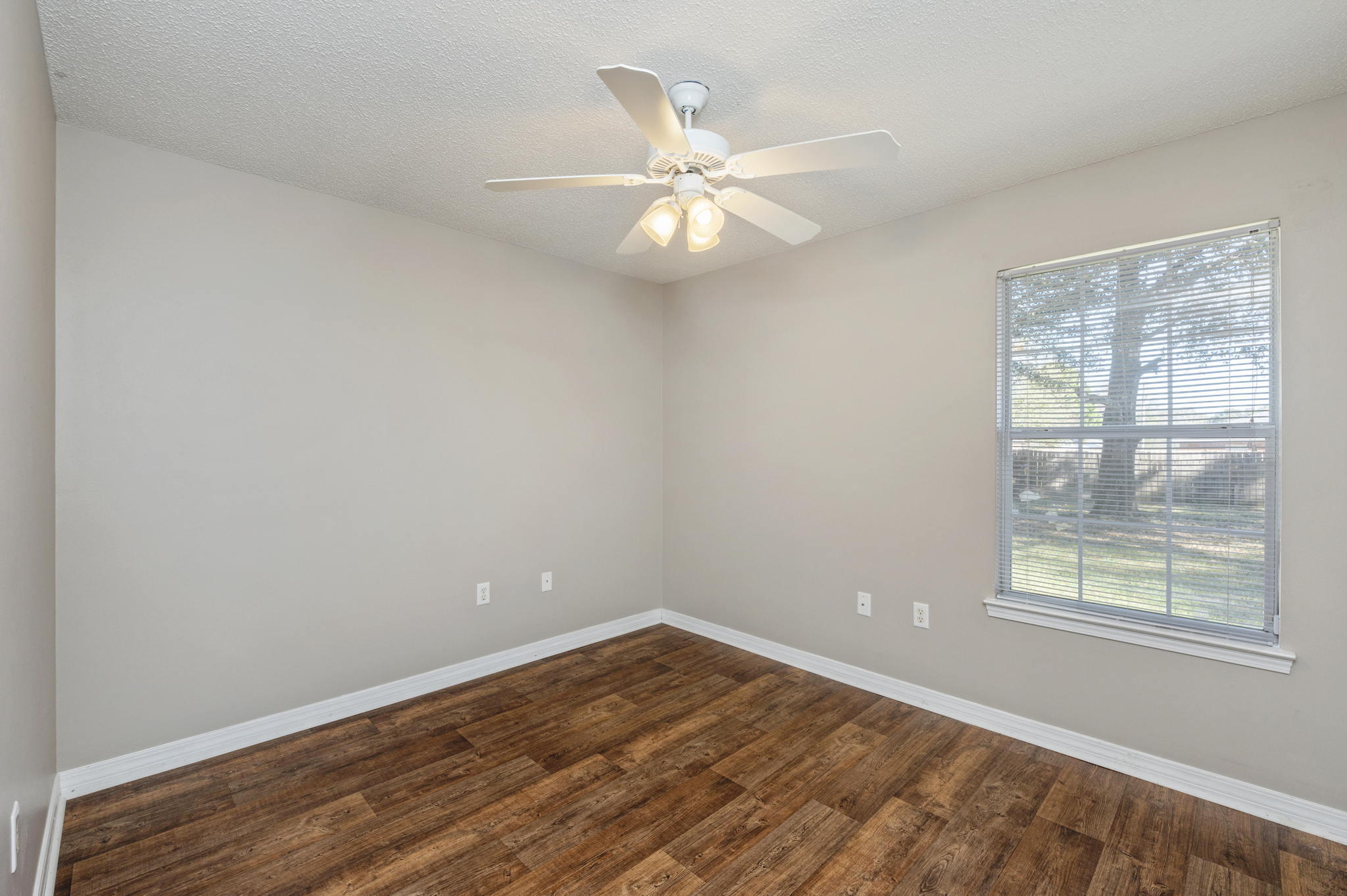 6235 Winstead Road Crestview, FL 32539 - Photo 19 of 31 an empty room with wooden floor fan and windows