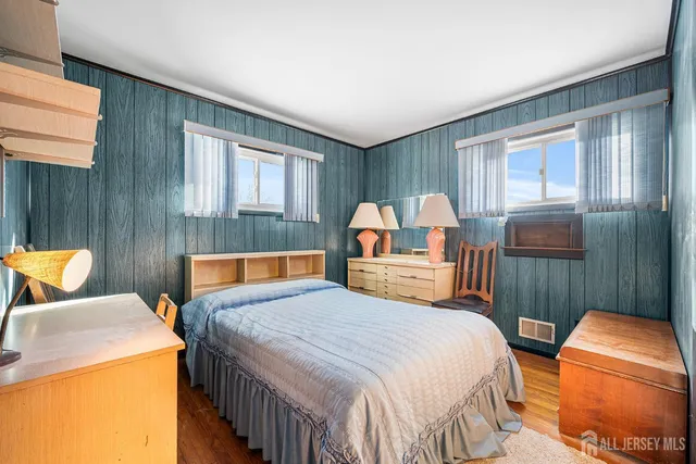 a bedroom with a bed and a lamp on the dresser