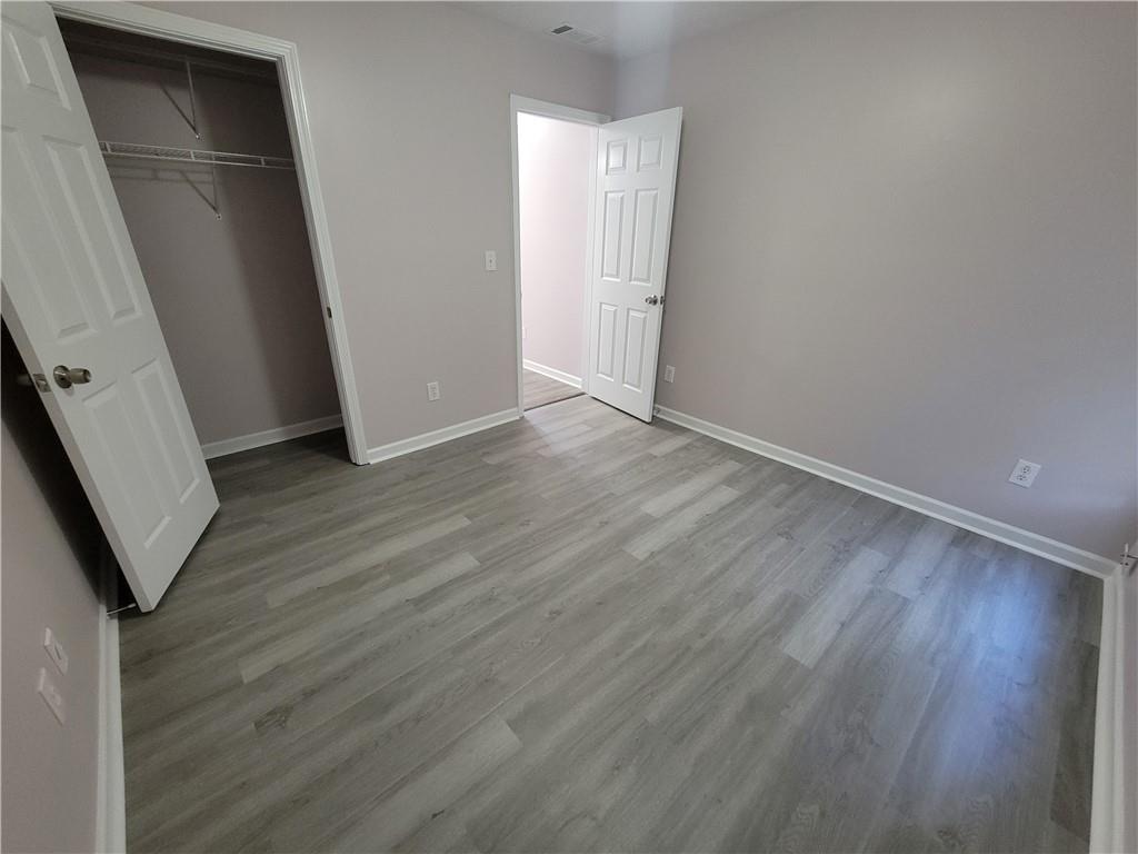 2213 Carlton Chase Road Dacula, GA 30019 - Photo 22 of 30 an empty room with wooden floor and entrance