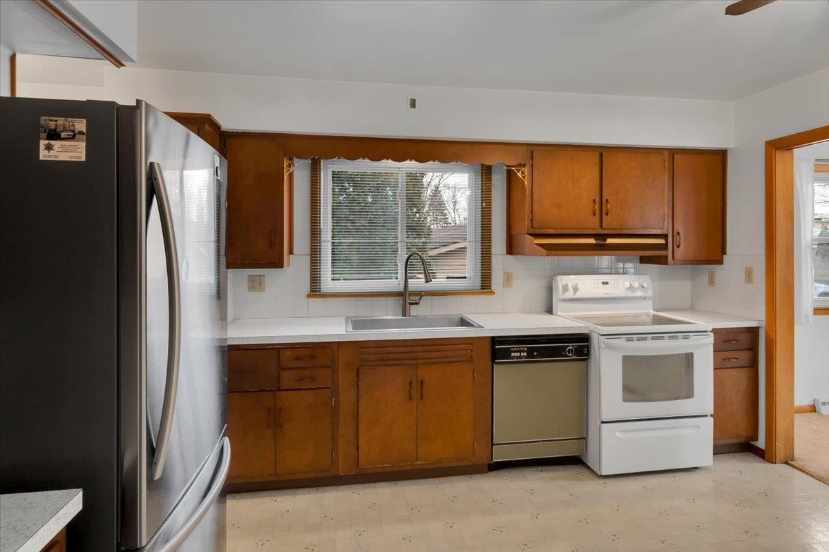 1636 Whitney Boulevard Belvidere, IL 61008 - Photo 13 of 36 a kitchen with stainless steel appliances granite countertop a stove a sink and a refrigerator with wooden cabinets