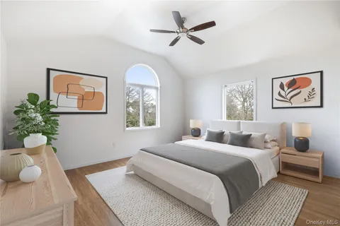 an empty room with wooden floor ceiling fan and windows
