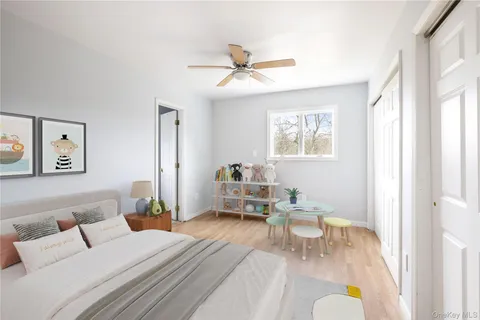 an empty room with wooden floor chandelier fan and windows