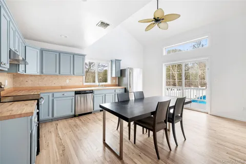 a kitchen with stainless steel appliances kitchen island granite countertop a dining table chairs and granite counter tops