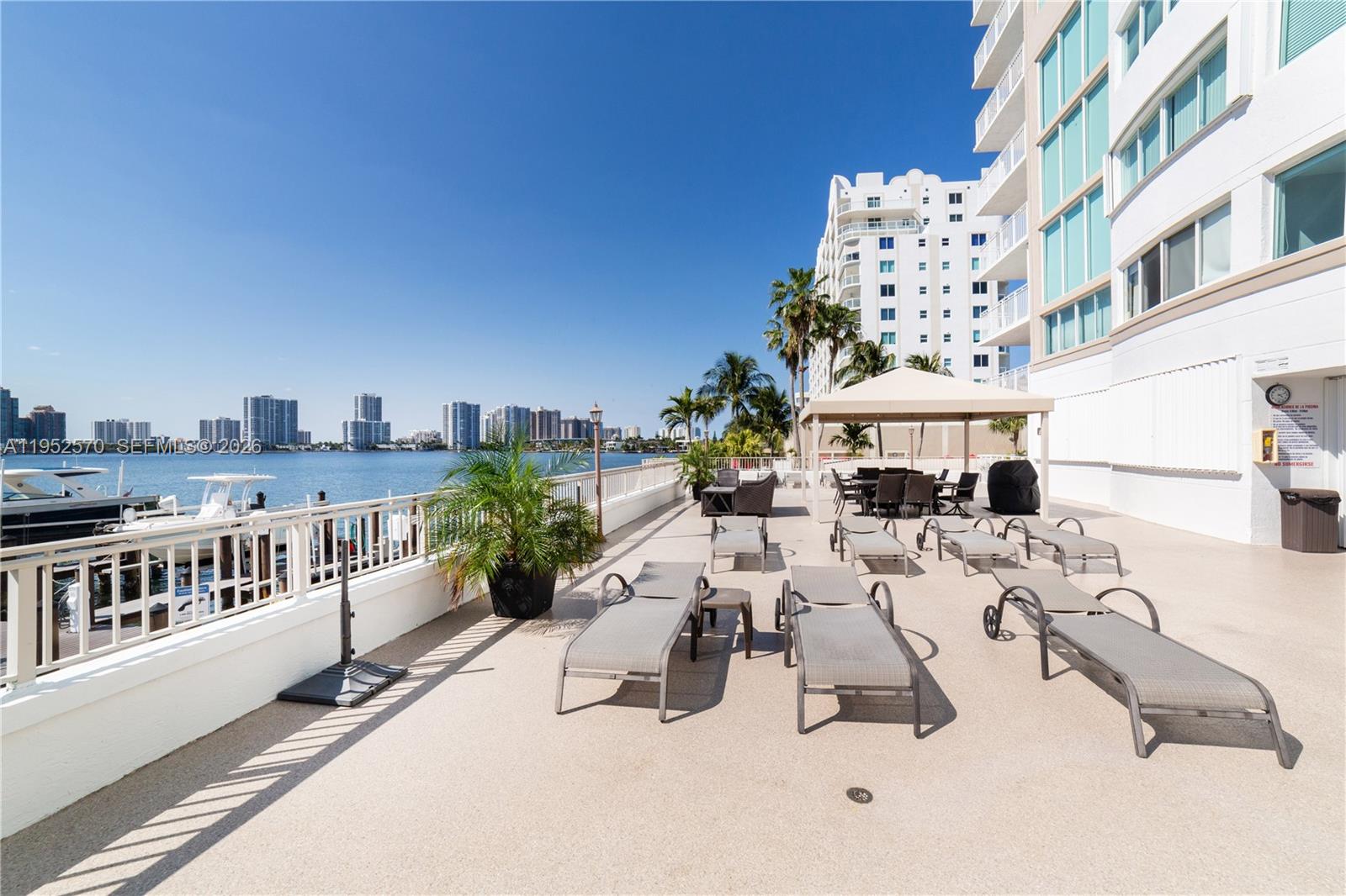 18000 North Bay Road, Unit 404 Sunny Isles Beach, FL 33160 - Photo 34 of 40 BBQ area with tables under the canopy
