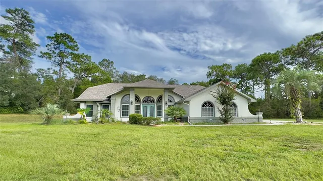 a living room with furniture and a dining table with kitchen view