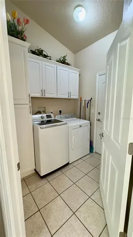 a bedroom with a bed chandelier and a window