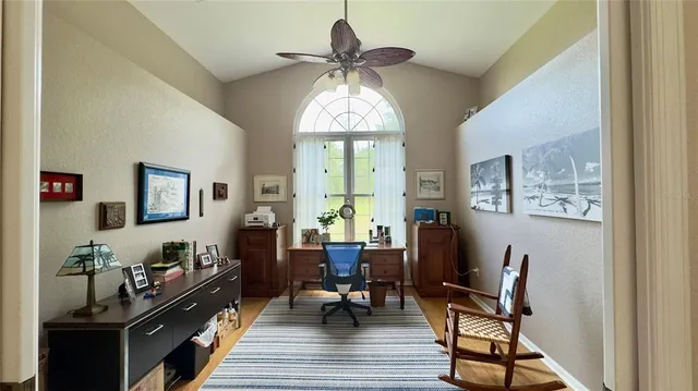 a living room with furniture kitchen view and a wooden floor