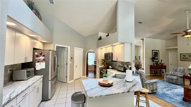 a view of a dining room with furniture a chandelier and large windows