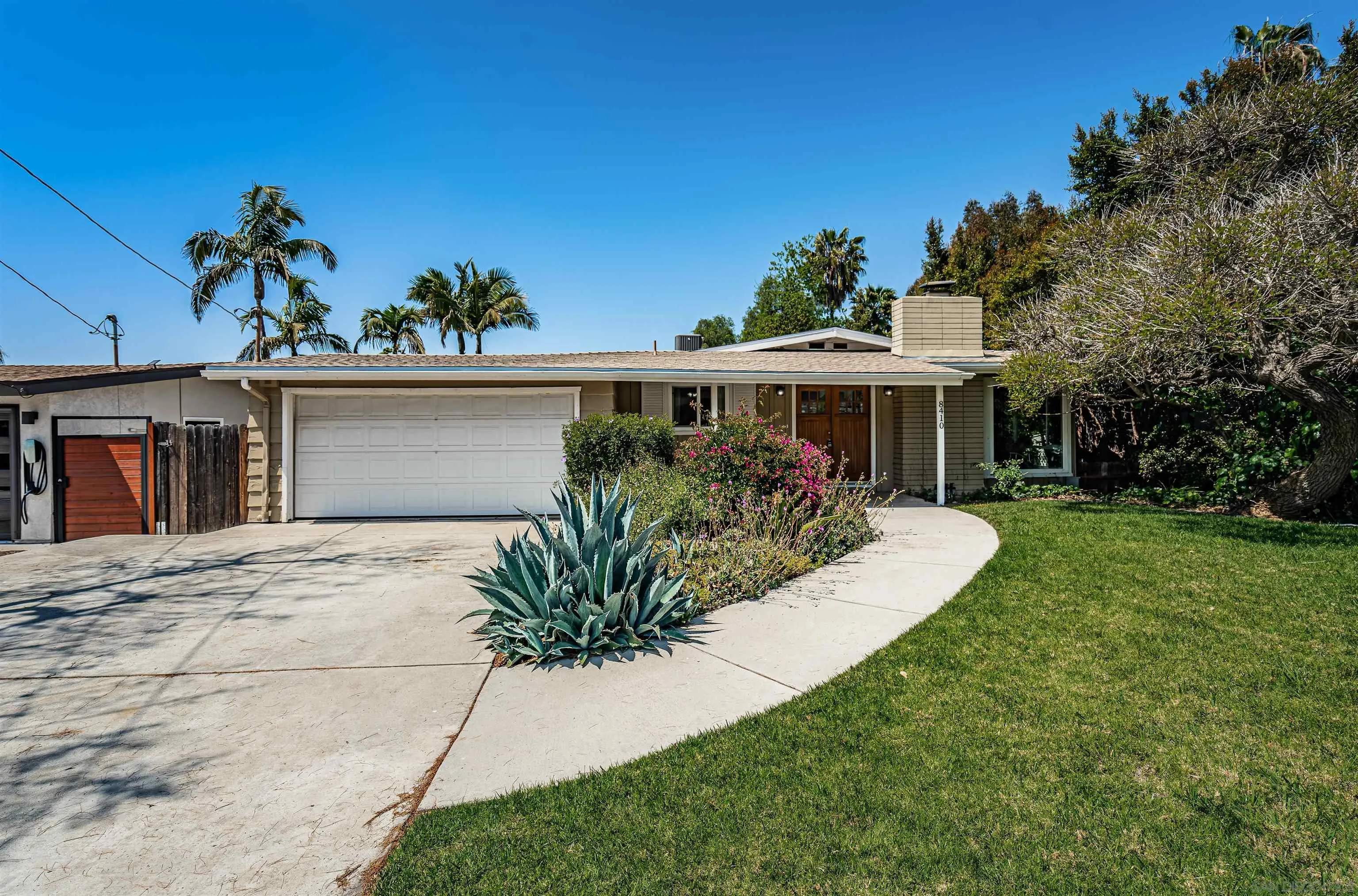 a front view of a house with a yard and potted plants