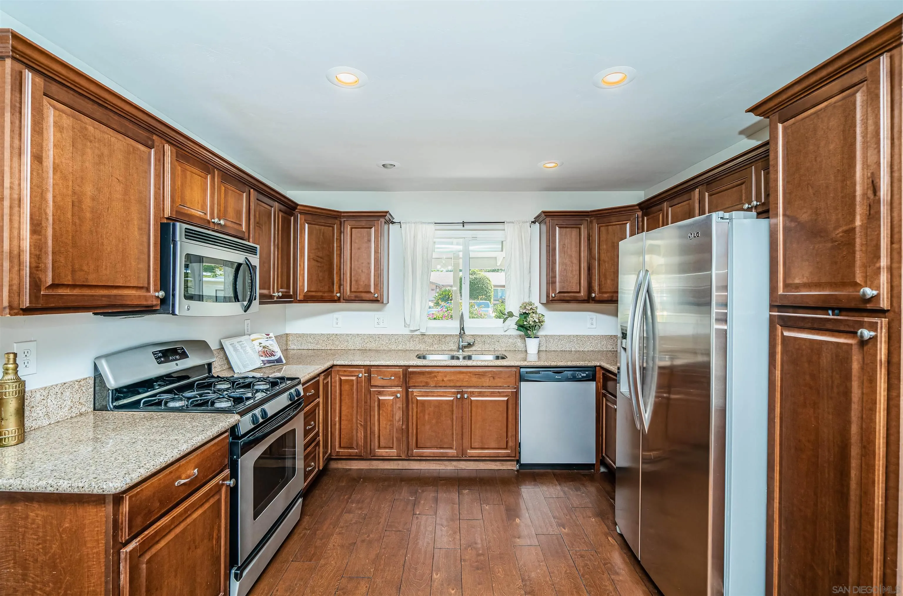 8410 Roy Street Lemon Grove, CA 91945 - Photo 13 of 40 a kitchen with stainless steel appliances granite countertop a refrigerator a sink dishwasher a stove and white countertops with wooden floor