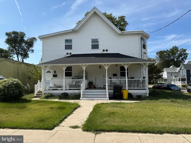 a front view of a house with a garden and plants