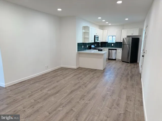 a kitchen with granite countertop a refrigerator and a stove top oven
