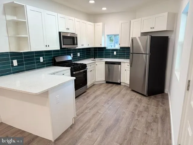 a kitchen with a refrigerator a microwave a sink and cabinets